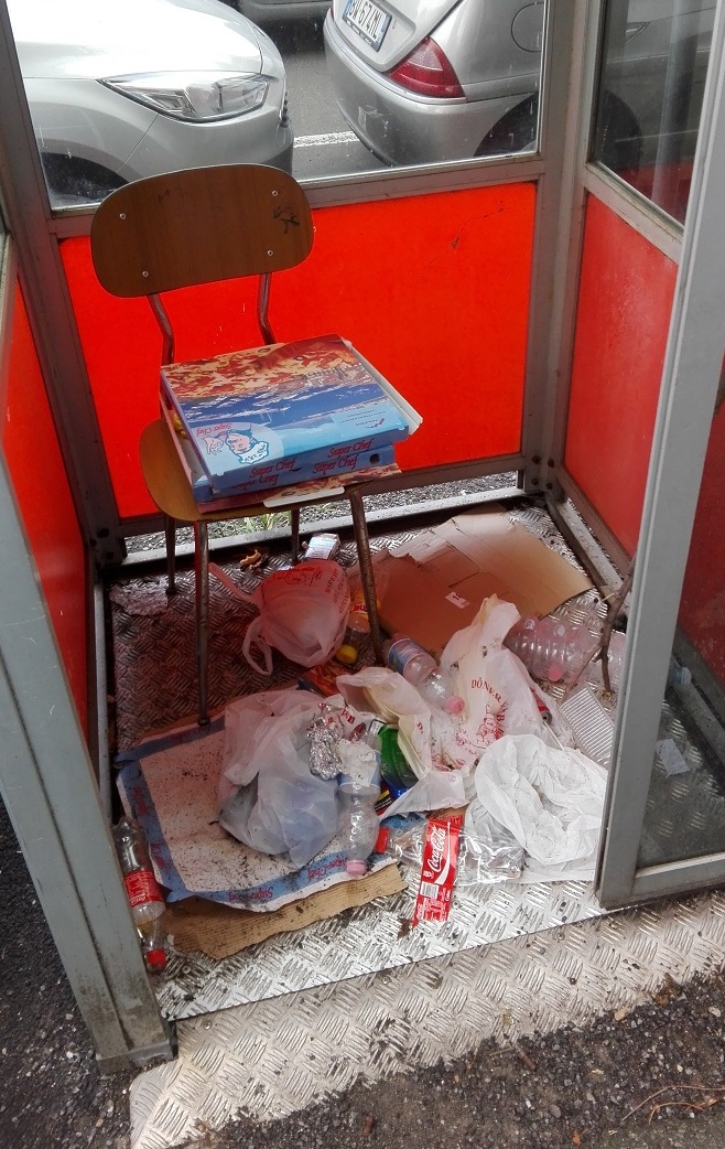 Cabina del telefono ridotta a immondezzaio